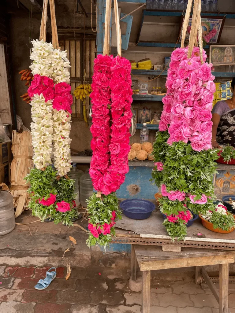 drei Blumenkränze sind zu sehen. Diese hängen an einem Seil. Die Blumen sind strahlen pink.
